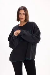 Buzo oversize color marrón con cuello redondo, mangas largas amplias y puños acanalados. Presenta letras en relieve con efecto desflecado en el frente y ruedo con terminación desflecada.