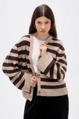 Saco de punto con diseño de rayas horizontales en tonos beige y marrón, cuello en V, cierre frontal con botones y bolsillos laterales. Presenta un corte holgado y mangas largas con puños acanalados.