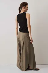 Blusa musculosa de punto color negro, con textura acanalada y silueta ajustada al cuerpo, decorada con una línea de ojalillos metálicos frontales.