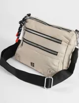 Bandolera negra de poliéster con múltiples compartimentos frontales con cierre metálico, correa ajustable y detalles en color verde lima en los tiradores.