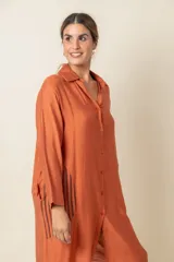 Túnica marrón de viscosa texturizada con cierre de botones, bolsillos laterales y detalle de rayas verticales en los bolsillos.