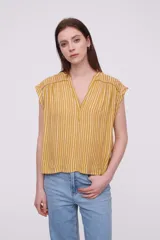 Blusa sin mangas de corte holgado, confeccionada en tela de viscosa con estampado de rayas verticales en tonos mostaza y blanco. Presenta cuello en V profundo y detalles bordados en los hombros.