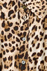 Vestido midi con cuello camisero, botonadura frontal y mangas cortas, con estampado de leopardo, elástico en la cintura y cinturón extraíble para atar.