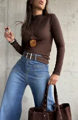 Polera de cuello alto y manga larga, confeccionada en tejido elástico color chocolate.