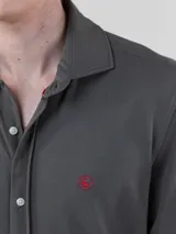 Camisa gris de punto liso para hombre, confeccionada en 100% algodón. Corte regular fit, cuello italiano, manga larga con puño simple y logo bordado en rojo en el pecho.