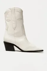 Bota de cuero negra con caña media, punta fina y taco bloque. Diseño estilo western con bordados decorativos.