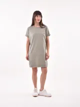 Vestido corto de manga corta, color verde militar con rayas horizontales finas en blanco. Tiene un bolsillo de parche en el pecho.