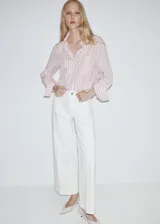 Jeans estilo wide leg de tiro alto en color blanco, con bolsillos de parche delanteros y cierre de cremallera y botón.
