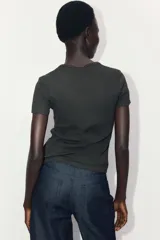 Remera negra de manga corta, confeccionada en punto acanalado con diseño entallado y cuello redondo fino.
