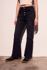 Pantalón de jean negro de corte flare con tiro medio y cierre frontal con botones.