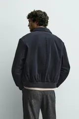 Cazadora regular fit confeccionada en pana de algodón con interior ligeramente acolchado. Presenta cuello solapa, cierre frontal con cremallera, bolsillos laterales de vivo y acabados en rib en puños y cintura.
