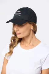 Gorro con visera de lona rosado con bordado frontal en tonos verde y violeta.