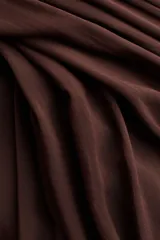 Pollera larga de corte holgado en modal, color marrón, con cintura elástica de tiro alto y frunces alrededor que aportan volumen.