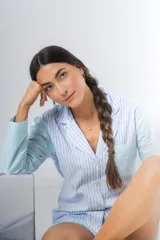 Pijama de algodón a rayas verticales celestes y blancas, compuesto por una camisa de manga larga con botones y un short con elástico en la cintura.