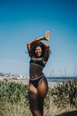 Bikini negro con ribetes blancos, compuesto por un corpiño deportivo con logo y una bombacha de corte clásico.