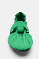Zapato tipo bailarina de estilo deportivo color verde, con tira ancha elástica y detalle de fruncidos en el empeine. Cuenta con talonera en contraste de materiales, suela plana engomada y acabado en punta redonda.