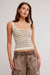 Musculosa acanalada de corte ajustado, con diseño de rayas horizontales en tonos beige, marrón y blanco. Posee escote cuadrado y un pequeño tajo frontal.
