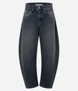 Pantalón de jean estilo baggy balloon, color gris oscuro con efecto lavado. Presenta cintura mediana con trabillas, cierre de botón y cremallera, bolsillos funcionales y recortes laterales que definen su silueta redondeada.