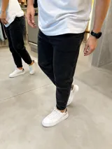 Pantalón de jean slouchy para hombre, color negro con efecto gastado, corte relajado y botamangas con vuelta.