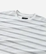 Remera de corte boxy con cuello redondo y mangas cortas. Presenta un diseño de rayas horizontales finas en tonos gris sobre fondo blanco.