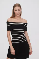 Top negro de tejido de punto con escote off-shoulder y rayas horizontales blancas.