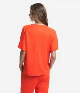 Blusa de manga corta color naranja, confeccionada en tejido Orly, con escote en V con detalle de costuras trabajadas.