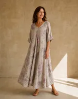 Vestido largo beige con estampado floral en tonos rosados y grises, escote en V y mangas cortas holgadas.