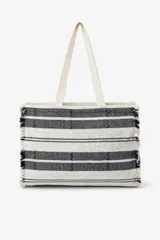 Bolso tote tejido a mano con diseño de rayas horizontales en blanco y negro, y detalles en zigzag. Los bordes laterales tienen flecos. Cuenta con dos asas de tela color crema.