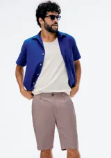 Bermuda estilo chino color rosado melange, con bolsillos laterales y traseros, y cierre frontal de botón y cremallera.