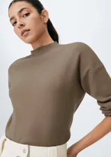 Sweater marrón de punto tejido con cuello alto.