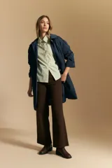 Camisa blanca de manga corta con volumen en los hombros, cuello camisero y cierre frontal con botones dorados.