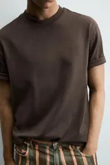 Camiseta de corte relajado confeccionada en tejido interlock de algodón con elasticidad, presenta cuello redondo y manga corta.