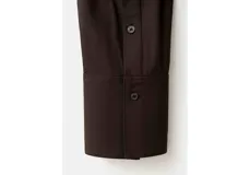 Camisa negra de manga larga con cuello clásico y cierre frontal abotonado.