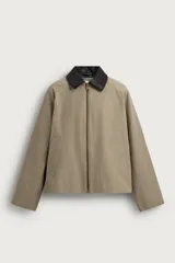 Sobrecamisa de corte relaxed fit color beige con cuello solapa en efecto piel de color negro a contraste, manga larga, bolsillos de vivo en la cadera y cierre frontal con cremallera.