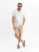 Camisa de manga corta de algodón en color beige, con cuello camisero y cierre frontal de botones, con diseño estampado sutil.