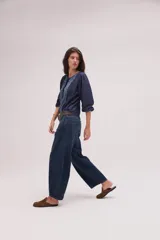 Pantalón jean de algodón con corte barrel y tiro bajo, de color azul, con bolsillos delanteros y traseros.