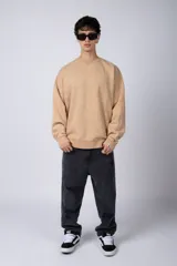 Buzo de cuello redondo con efecto de teñido artesanal acid wash. Presenta un corte oversize, mangas largas con puños acanalados y etiqueta pequeña en el puño izquierdo.