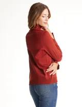 Polera de tejido fino, color rosado, con cuello alto, manga larga y detalle de tajo en los puños.