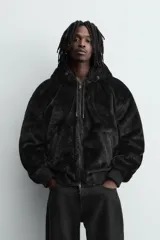 Cazadora bomber reversible de corte relajado confeccionada en tejido técnico. Presenta capucha con interior de pelo sintético, cierre frontal con cremallera de doble dirección, bolsillos laterales y puños y bajo con acabado en rib elástico.