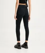 Pantalón skinny de jean negro, de cintura alta, con bolsillos y trabillas para cinturón.