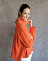 Sweater color crudo de cuello alto con mangas largas y corte holgado.