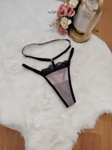 Tanga de microtul color tostado con detalles de encaje negro en la parte superior y tiras elásticas regulables.