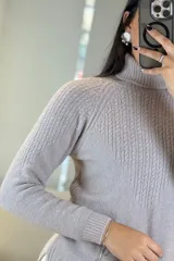 Buzo de punto con cuello alto, diseño de textura acanalada en el frente y mangas largas con puños ajustados.