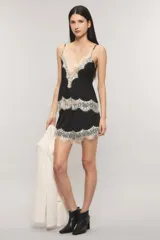 Short de satén texturado color blanco, de tiro medio con elástico en la cintura y detalle de puntilla estilo chantilly negra en el ruedo.