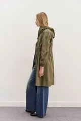 Campera impermeable negra a la rodilla de corte amplio, con cierre frontal, capucha, bolsillos y elástico en los puños. Cuenta con cordones de diseño personalizado en la cintura y la capucha, y detalles en símil cuero en bolsillos y cierre delantero.