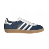 Championes adidas Gazelle de diseño clásico, confeccionados en gamuza azul con las icónicas tres tiras laterales en blanco. Presentan detalles en blanco en el talón y la lengüeta, con el nombre del modelo en dorado y una suela de goma color caramelo.