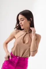 Top dorado de lurex con cuello halter y abertura en el pecho.