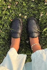 Mocasines de cuero negro con punta cuadrada y costuras artesanales de tientos de cuero pasados a mano en el empeine y alrededor.