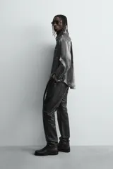 Pantalón slim fit confeccionado en piel, con diseño de cinco bolsillos, cierre frontal de cremallera y botón.