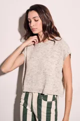 Chaleco de punto color crema con detalles en rosa y celeste, de corte holgado y mangas cortas.